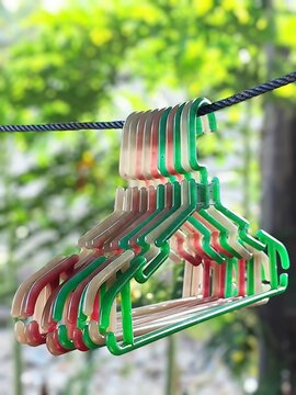 Colorful plastic clothes hangers hanging on a rope outdoor
