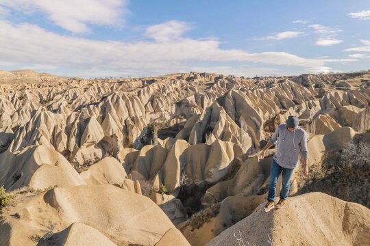 Person carelessly walking on the rock with a smartphone on the tripod to make a selfie in a scenic place. Exploratin of Cappadocia. Turkey