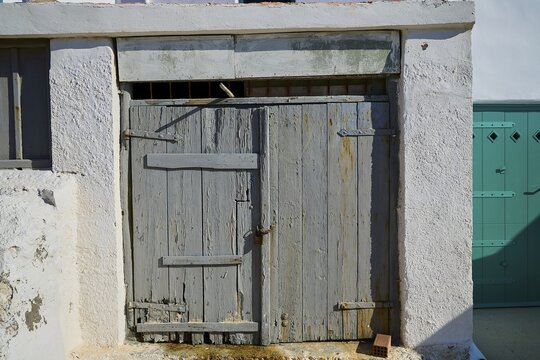 Weathered wooden door in old stone fa&ccedil;ade with rustic charm, Syrmata, boat garages, boathouse, boathouses, beach house, Goupa, Goypa, Goupa Kara, Kimolos, Cyclades, Greek Islands, Greece