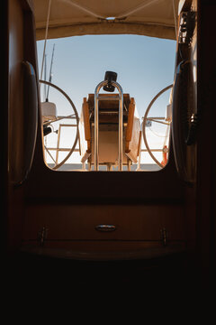 View from dark cabin  looking up to sailing yacht cockpit and steering helm at sunset