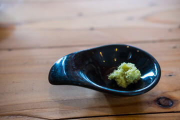 Wasabi paste in a small dish on wood table © Dontree