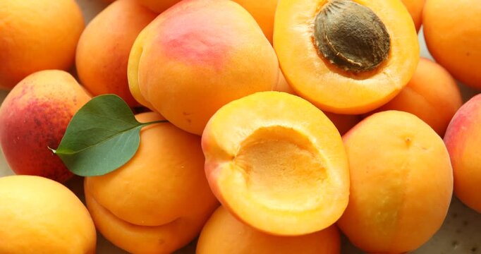 Fresh ripe apricots and green leaf on plate, closeup