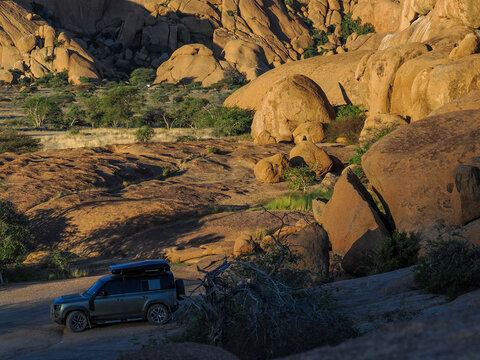Off-road vehicle driving in Spitzkoppe desert, copy space