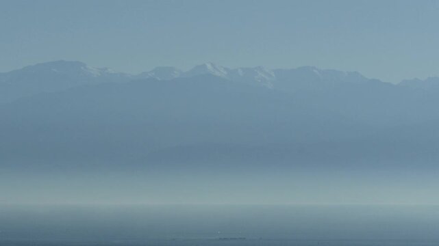 春霞の富山湾に浮かぶ冠雪した立山連峰の水墨画のような風景