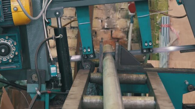 Band Saw Machine Cutting Plastic Pipe: Industrial Workshop Close-Up with Hydraulic Clamp and Roller Conveyor | Metal Cutting Equipment Feeding PVC Tube | Factory Plumbing Manufacturing Process