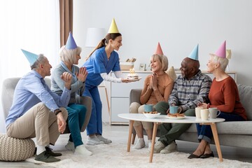 Joyful Happy Elderly Caucasian Group Of Six Celebrating Birthday Together With Cake And Candles In...