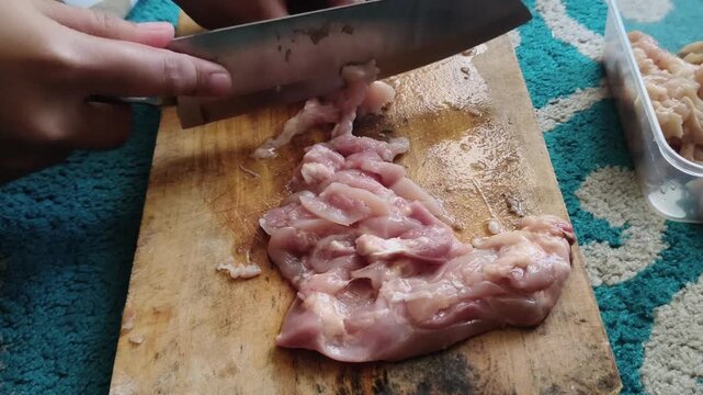 High angle view of home culinary preparation focusing on slicing raw fresh meat