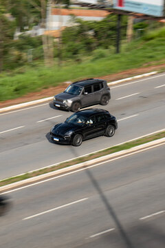 High-Angle View of Black Porsche Macan and Grey Jeep Renegade Driving on Highway
