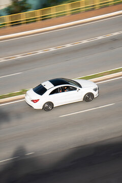 High-Angle View of a White Mercedes-Benz CLA Driving on an Urban Highway