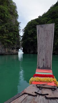 Traditional thai longtail boat sailing through lagoon
