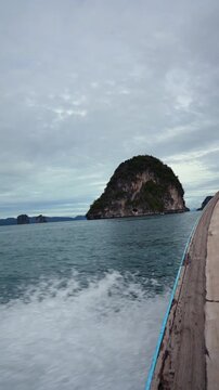 Traditional long-tail boat cruising through tropical sea