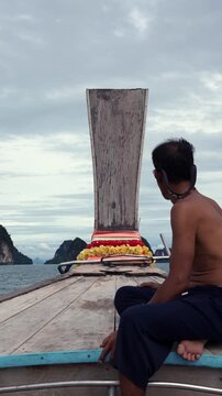 Fisherman riding a traditional thai long-tail boat