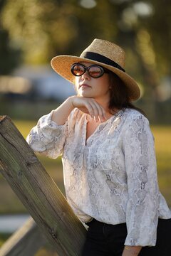 Woman in hat sitting on the beanch.