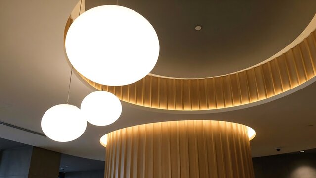 Contemporary interior with glowing round pendant lamps and wooden architectural elements