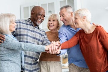 Joyful Group Of Five Seniors, Including Men And Women Of Various Ethnicities, Smiling And Holding...