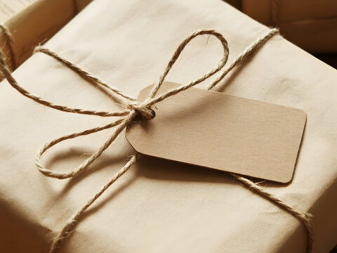 Gift box wrapped in brown paper tied with twine and a blank tag for personalization during a celebration