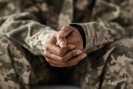 Calm And Focused Black Female Soldier Sitting With Hands Together In Military Uniform, Demonstrating A State Of Composure In A Military Setting. Emphasizing Strength And Discipline, Military Concept.