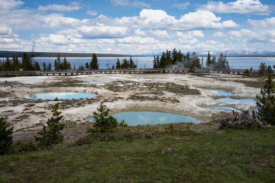 Turquoise water in geothermal hot springs in West Thumb Geyser Basin, sunny day traveling in Yellowstone National Park for summer vacation
