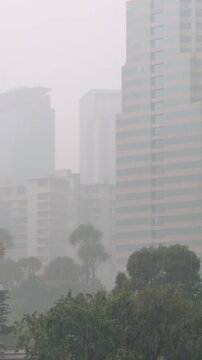 Vertical View of Kuala Lumpur Towers Through Tropical Rain and Mist
