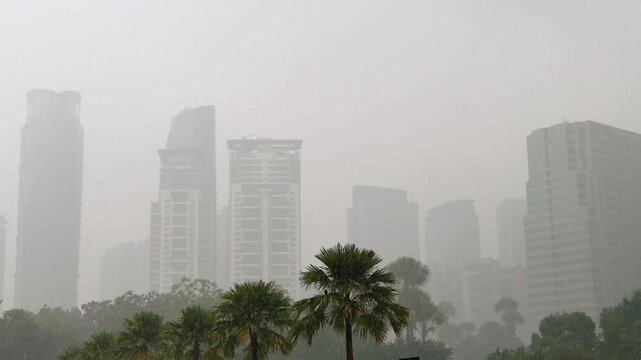 Kuala Lumpur City Skyline silhouettes with Palm Trees in Tropical Monsoon Rain