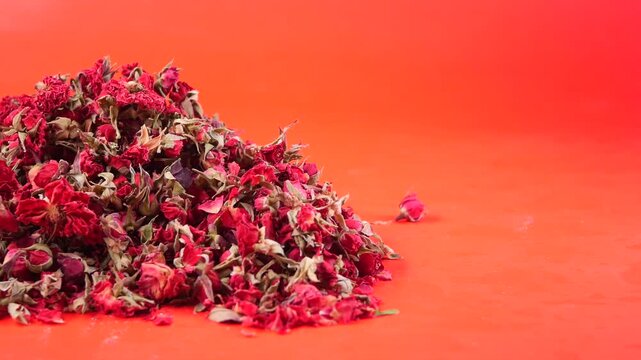 Dried rose petals on bright orange background
