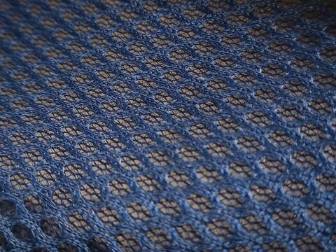 Close up of blue mesh fabric texture with a blue honeycomb pattern