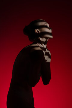 Woman poses gracefully against a bold red backdrop