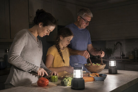 Family preparing dinner safely during a neighborhood power outage