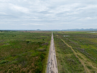 Naklejka premium Aerial View of Rural Road Through Green Wetland Landscape
