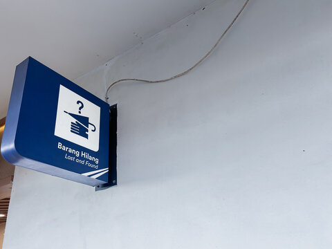 Blue wall mounted bracket sign for lost items with electrical wire, suitable for directional signage or wayfinding in a modern space.