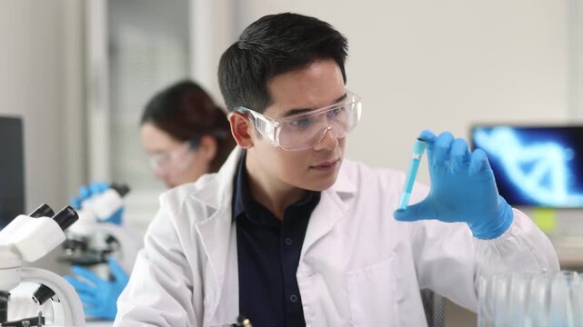 A young male scientist is conducting experiments in the laboratory with a stern expression.
