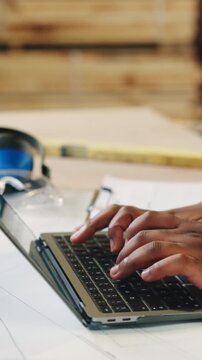 Carpenter, hands or typing with laptop in workshop for freight schedule, stock or distribution. Employee, artisan or furniture designer with computer for wood production or supply chain in warehouse