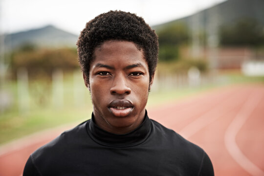 Portrait, teenager and student on track for fitness, exercise and practice for school challenge. Serious, African boy or runner at stadium for marathon training, sprint and competition at sport event