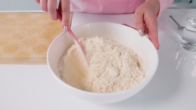 Mixing flour and dry ingredients in a bowl during baking preparation