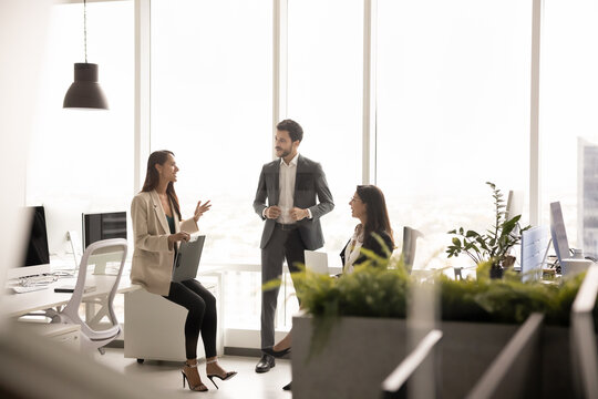 Team members engage in discussion during meeting in coworking, listen ideas of female leader, explains tasks, solution, provide guidance, take part in briefing in office workplace. Teamwork, business
