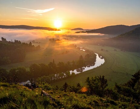 Sunrise over a misty river valley with rolling hills.
