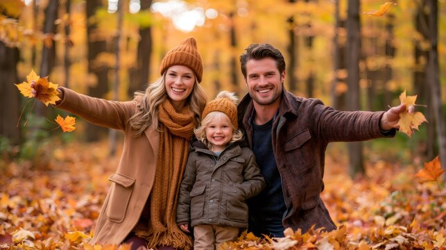 Family enjoying autumn day throwing colorful leaves