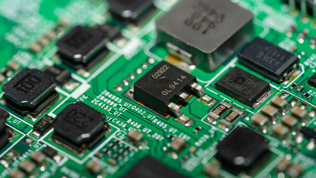 Extreme macro of SMD power transistor and diode on green circuit board