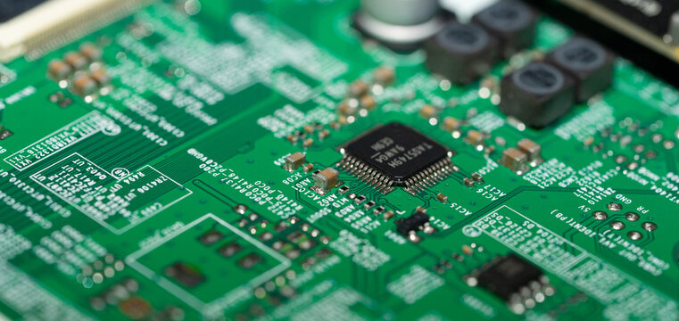 Selective focus microchip on green printed circuit board with shallow depth of field