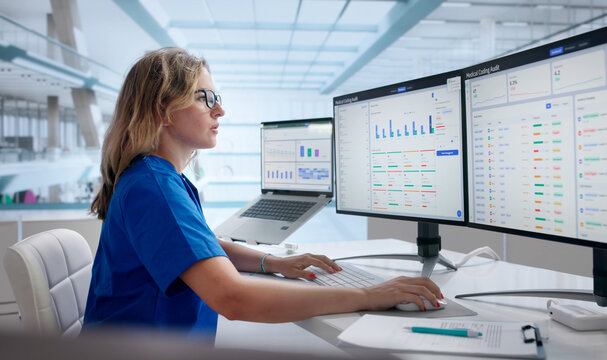 Woman Using Laptop To Check Medical Billing Data