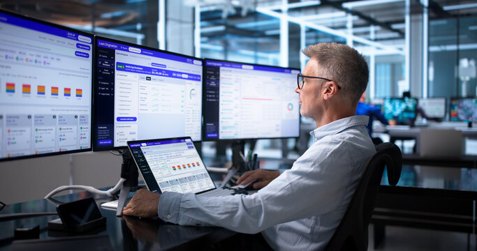 Loan Officer Carefully Reviewing Credit Risk Scores On Laptop