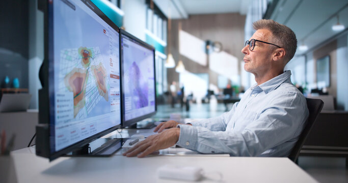 Environmental Scientist Analyzes Flood Risk Maps On Computer