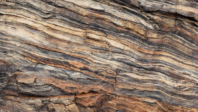 Natural rock strata texture with layered sedimentary stone patterns and geological formations.