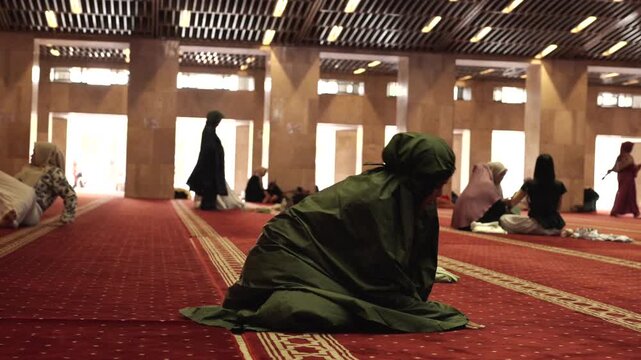 Muslim woman praying salah in mosque interior
