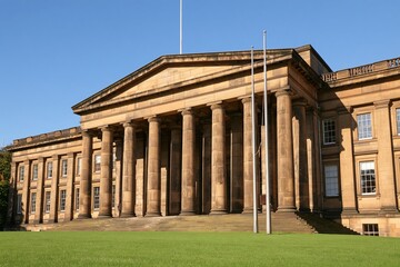 Obraz premium Grand classical building with stone columns on green
