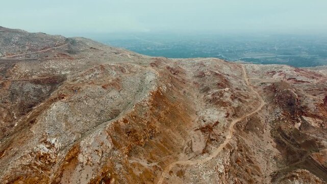Aerial view of Landi Kotal in Khyber District, Pakistan, showing a traditional mountain settlement surrounded by rugged rocky hills, vegetation, roads, and residential buildings. 