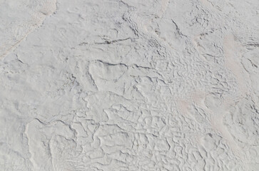 Fototapeta premium Natural white travertine texture at Pamukkale, Turkey, featuring mineral terraces and unique geological patterns.