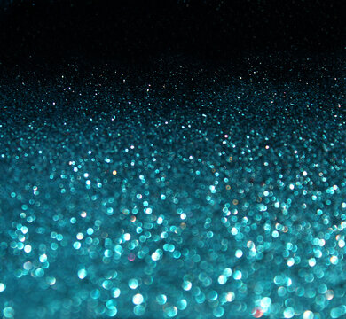 Abstract deep cyan blue glitter background with soft focus bokeh light spheres and shimmering particles, background