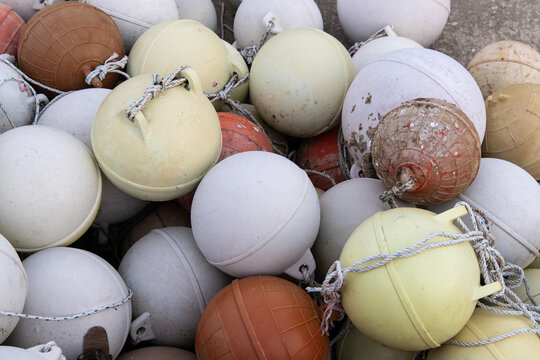 Pile of Colorful Fishing Buoys and Ropes at Harbor Dock