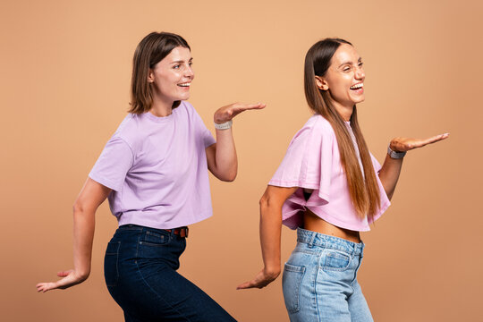 Young women friends dancing laughing having fun together